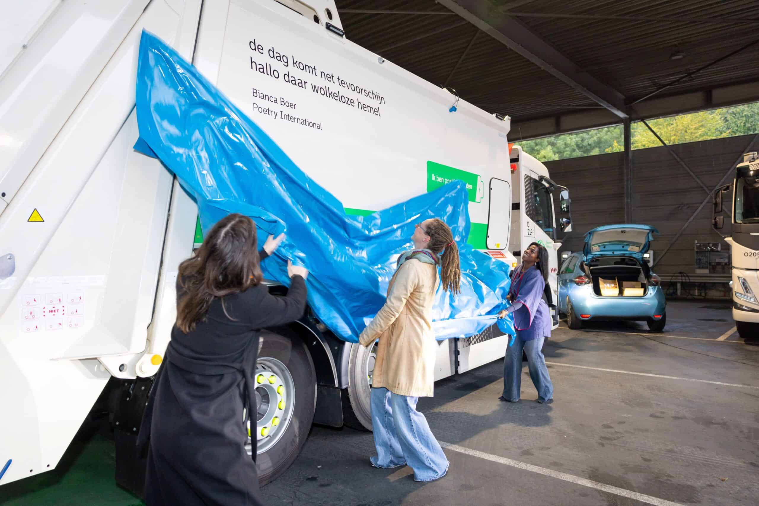 Alderman Joan Nunnely and Poetry International director Diana Chin-A-Fat unveil a line by poet Bianca Boer on a Rotterdam rubbish truck. Photo: Rhalda Jansen.